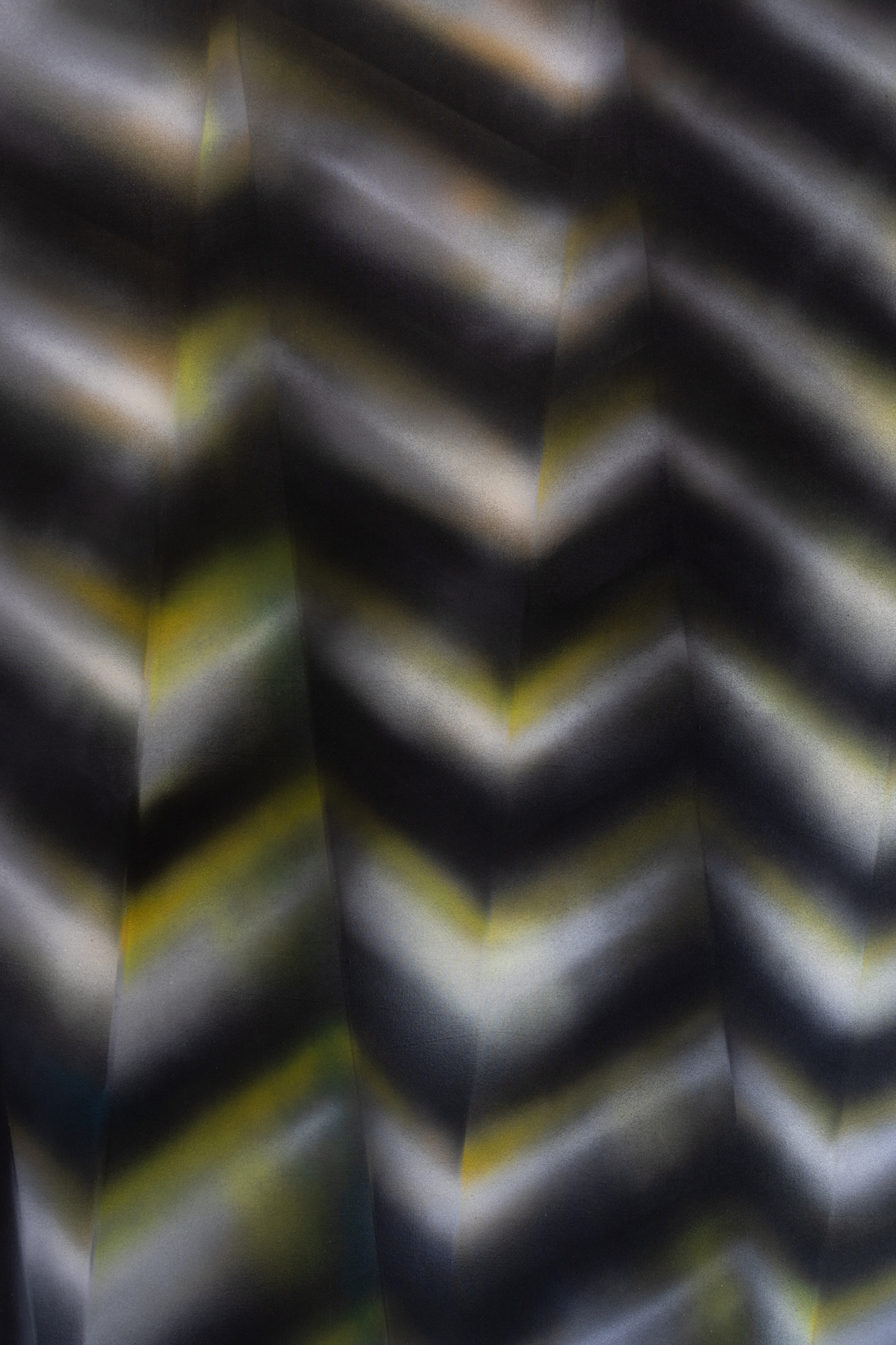 An abstract, zig zag pattern with black, white and yellow bands.